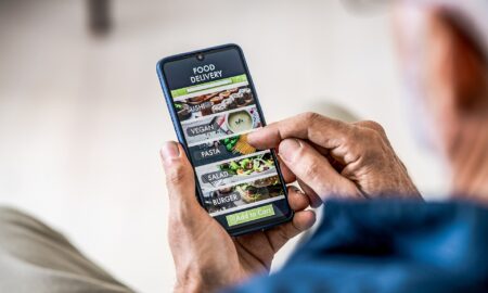 Elderly man ordering food via app at home or work.